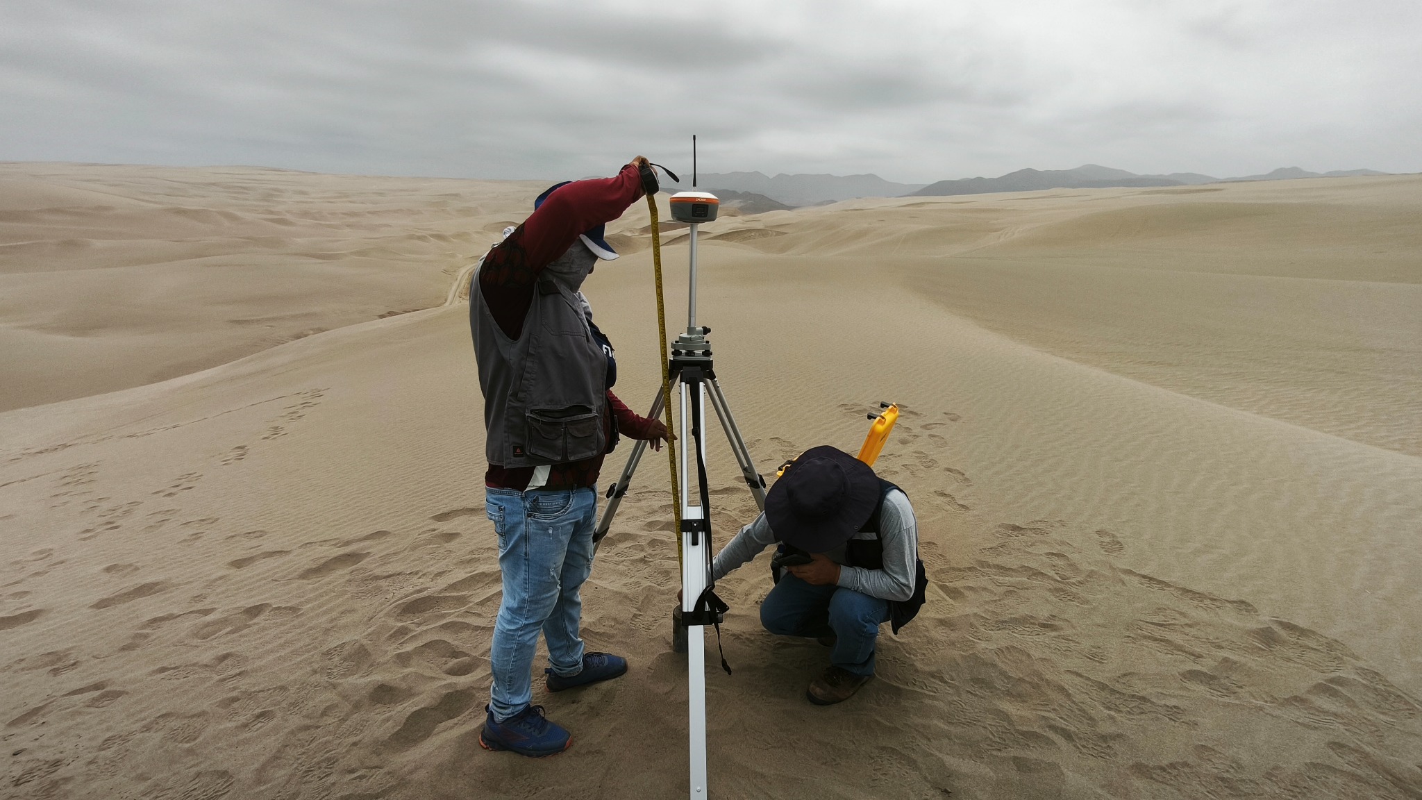 Personal midiendo en terreno arenoso con equipo GNSS