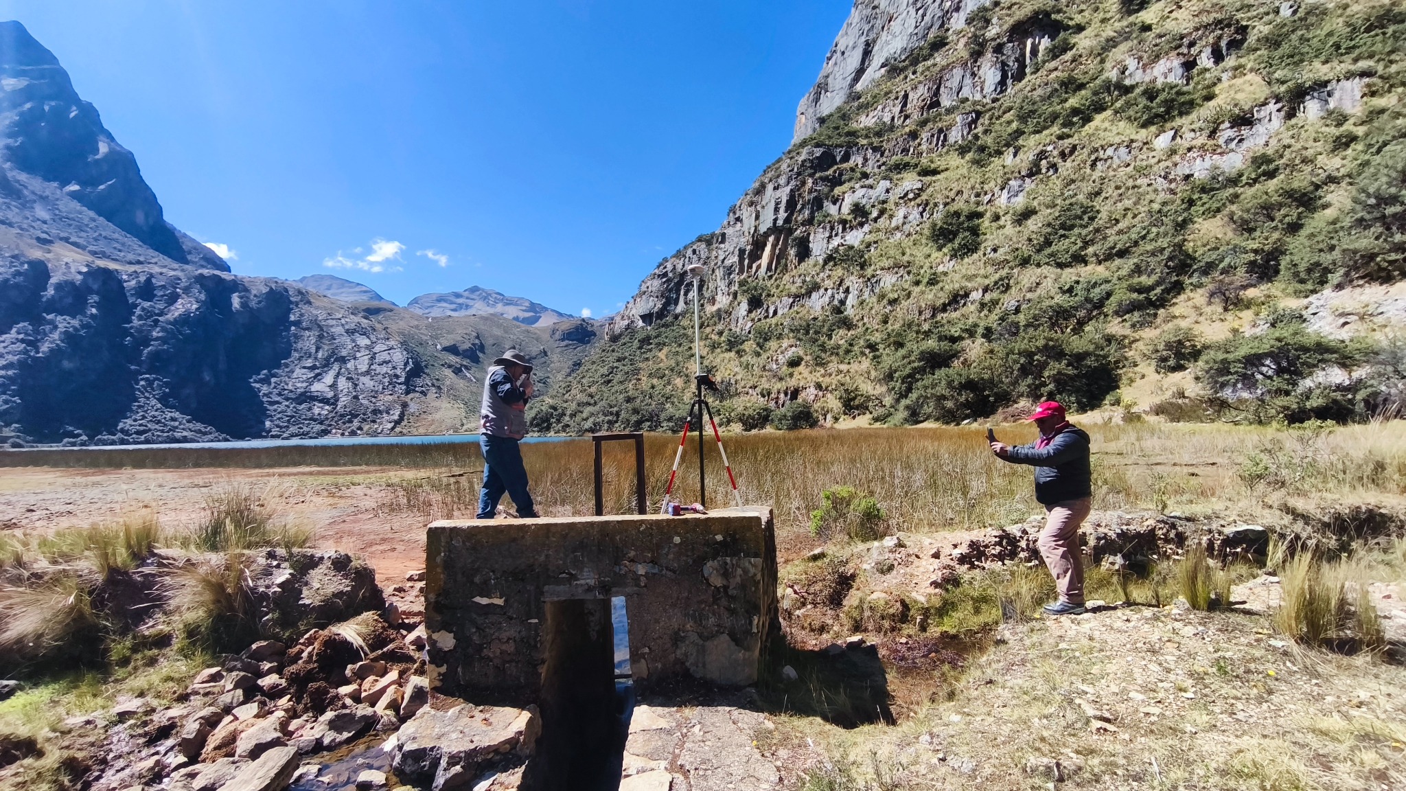 Personal realizando mediciones en campo junto a una laguna de la provincia de Oyón